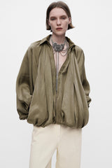 Model trägt Isandra Draped Statement Jacket in Olivgrün mit Oversized-Fit
