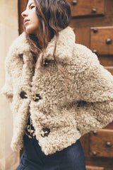 Detailansicht der beigen Teddyjacke mit flauschiger Struktur
