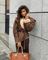 model trägt Serenya shearling jacke braun mit gürtel
