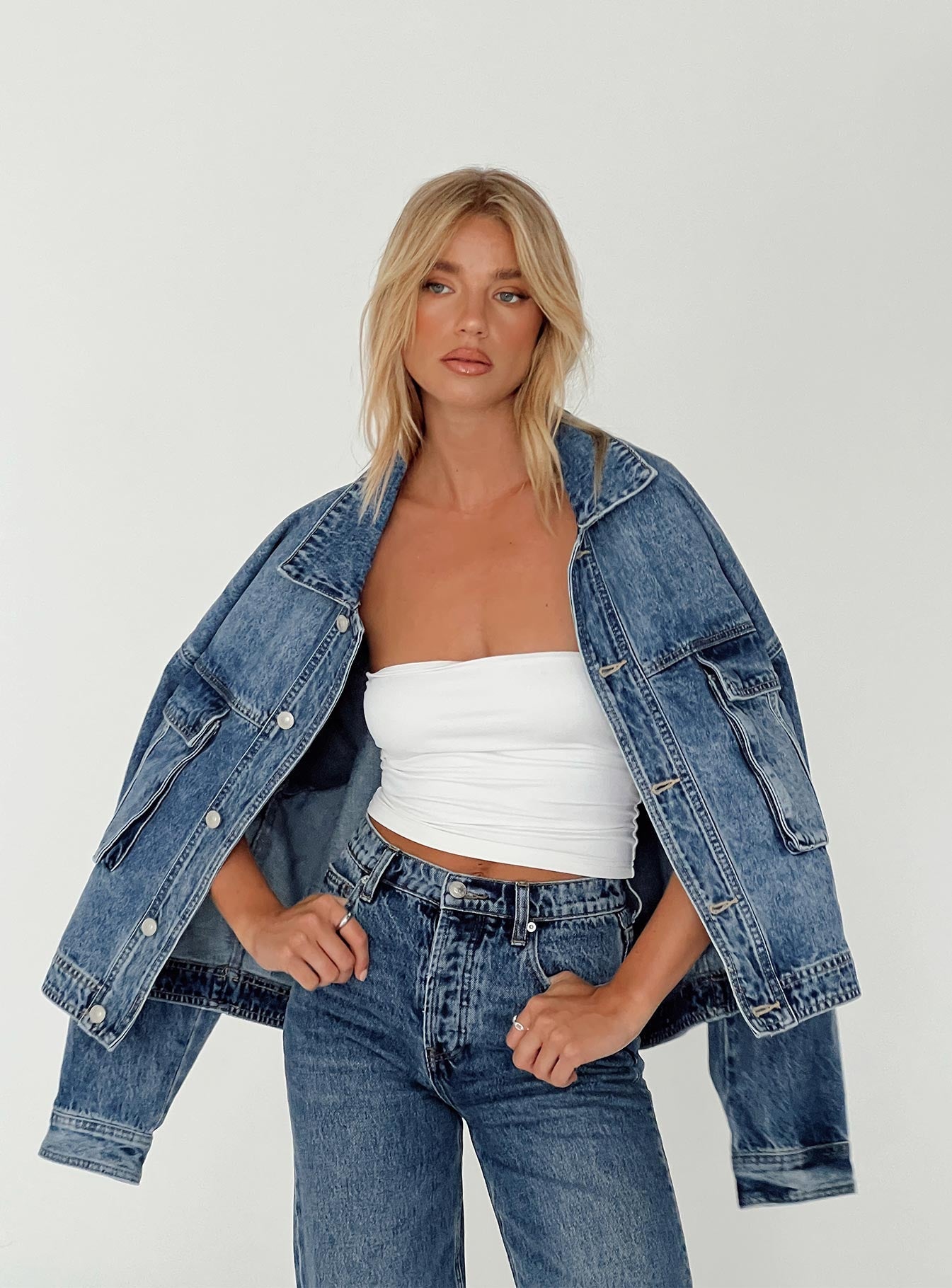 Model trägt Sloanea Denim Oversize Jeansjacke im Mid-Wash
