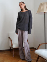 Elayne Knit in Grau, sitzend auf dem Sofa
