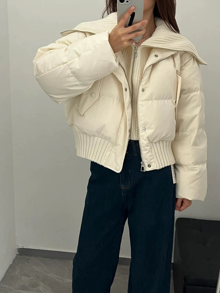 Frau in beiger Pufferjacke mit hohem Kragen und Reißverschluss