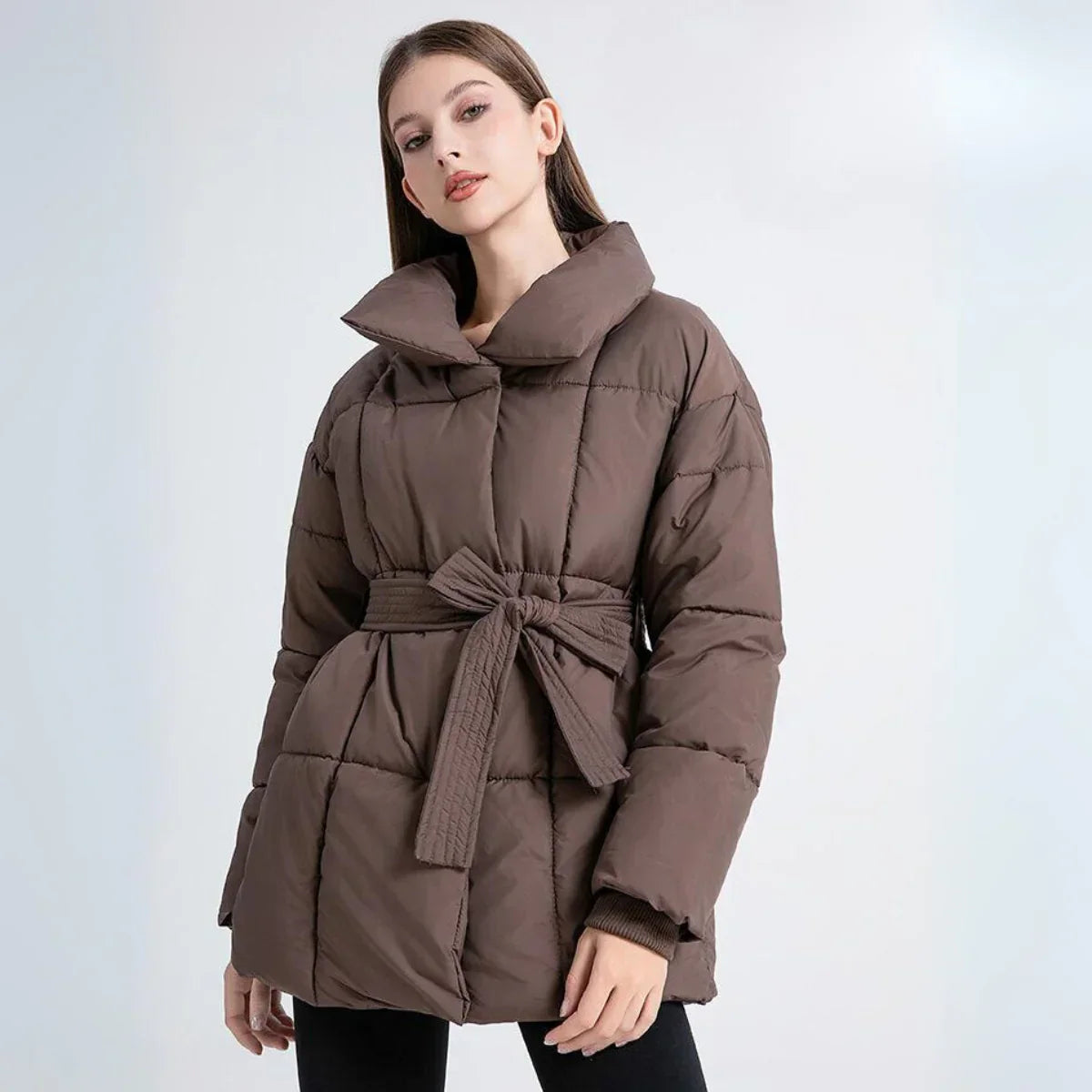 Frau trägt braune Arctic Allure Winterjacke mit Bindegürtel