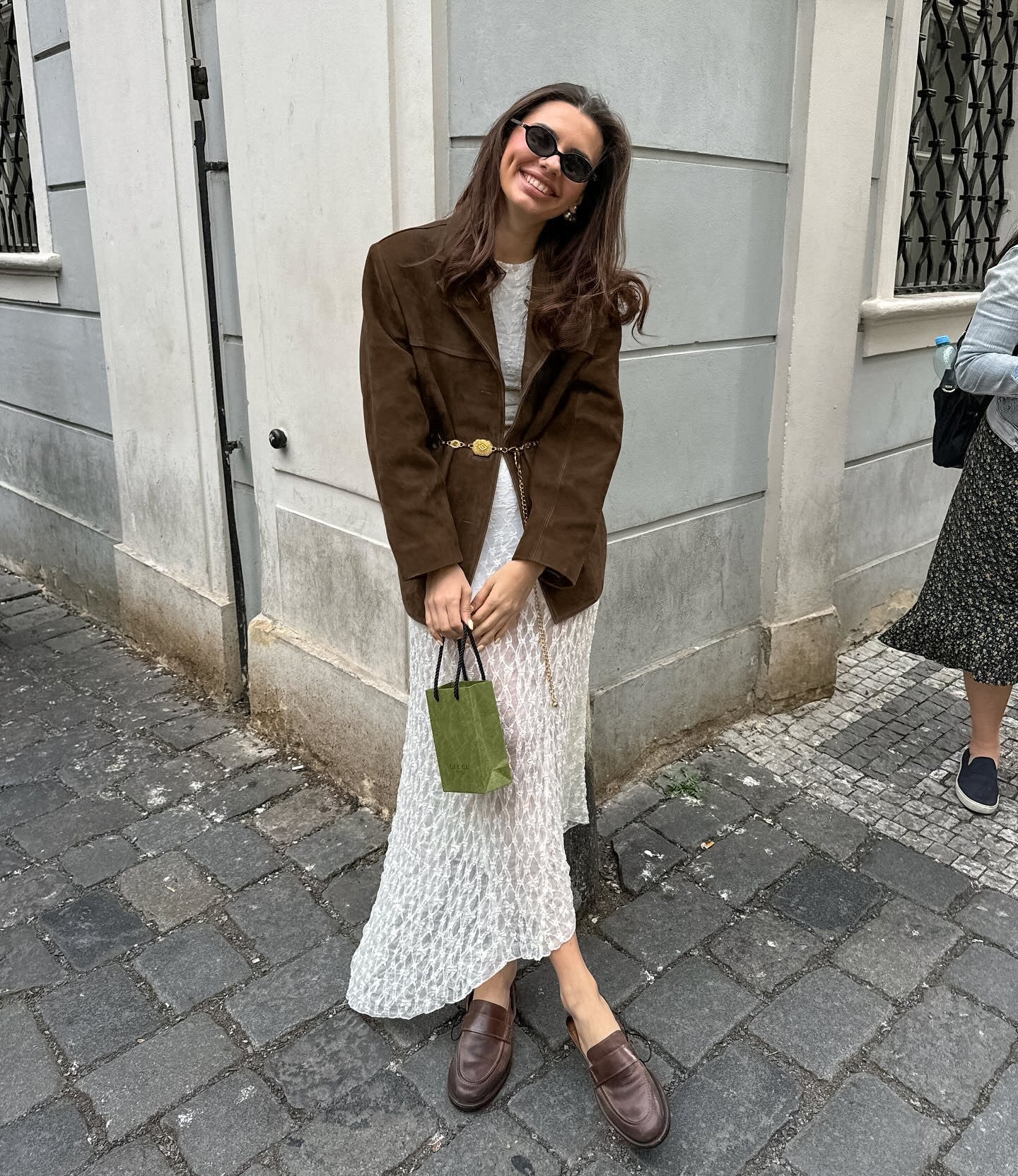 Model trägt Veloura Chic Übergangsjacke in Braun mit Kleid kombiniert
