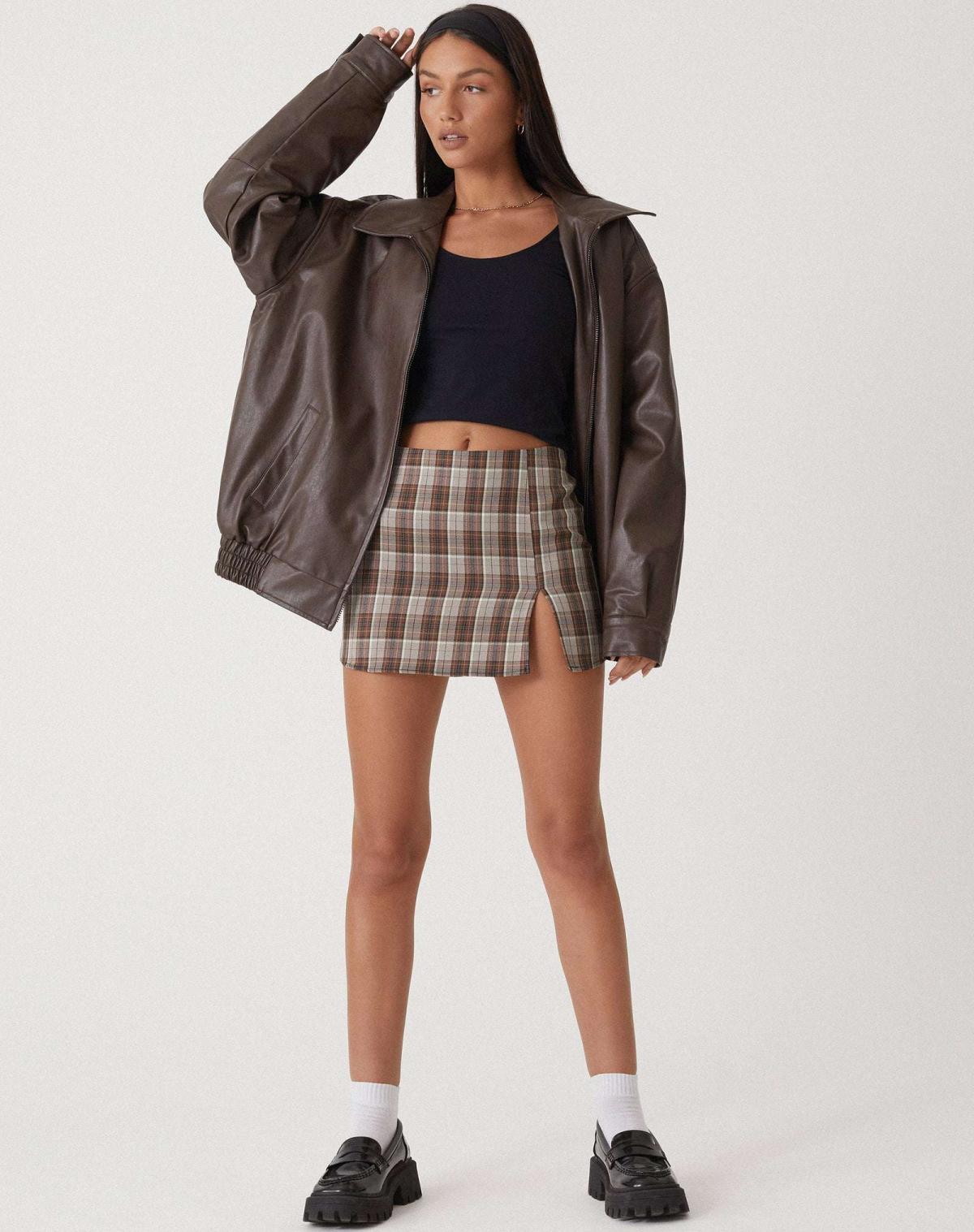 oversized braune Lederjacke mit Reißverschluss und elastischem Bund, kombiniert mit karriertem Minirock