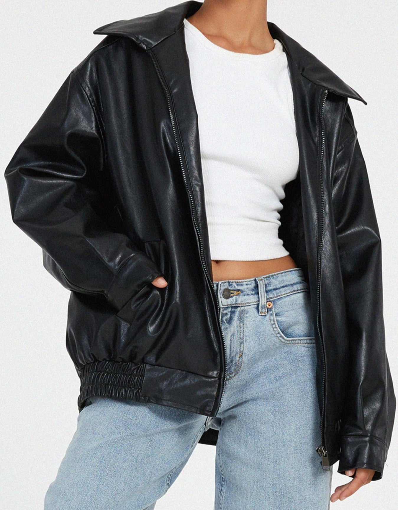 schwarze oversized Lederjacke mit elastischem Bund, kombiniert mit weitem Jeansschnitt
