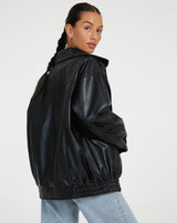 schwarze oversized Lederjacke kombiniert mit weißem Crop-Top und Mom-Jeans