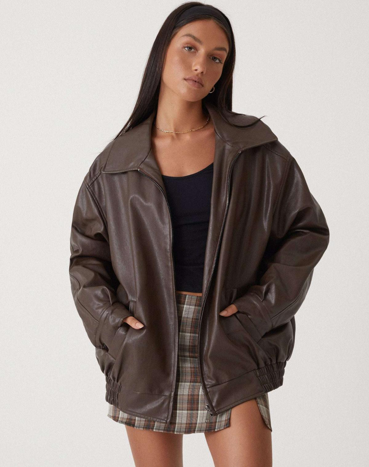oversized braune Lederjacke mit Reißverschluss und elastischem Bund, kombiniert mit karriertem Minirock