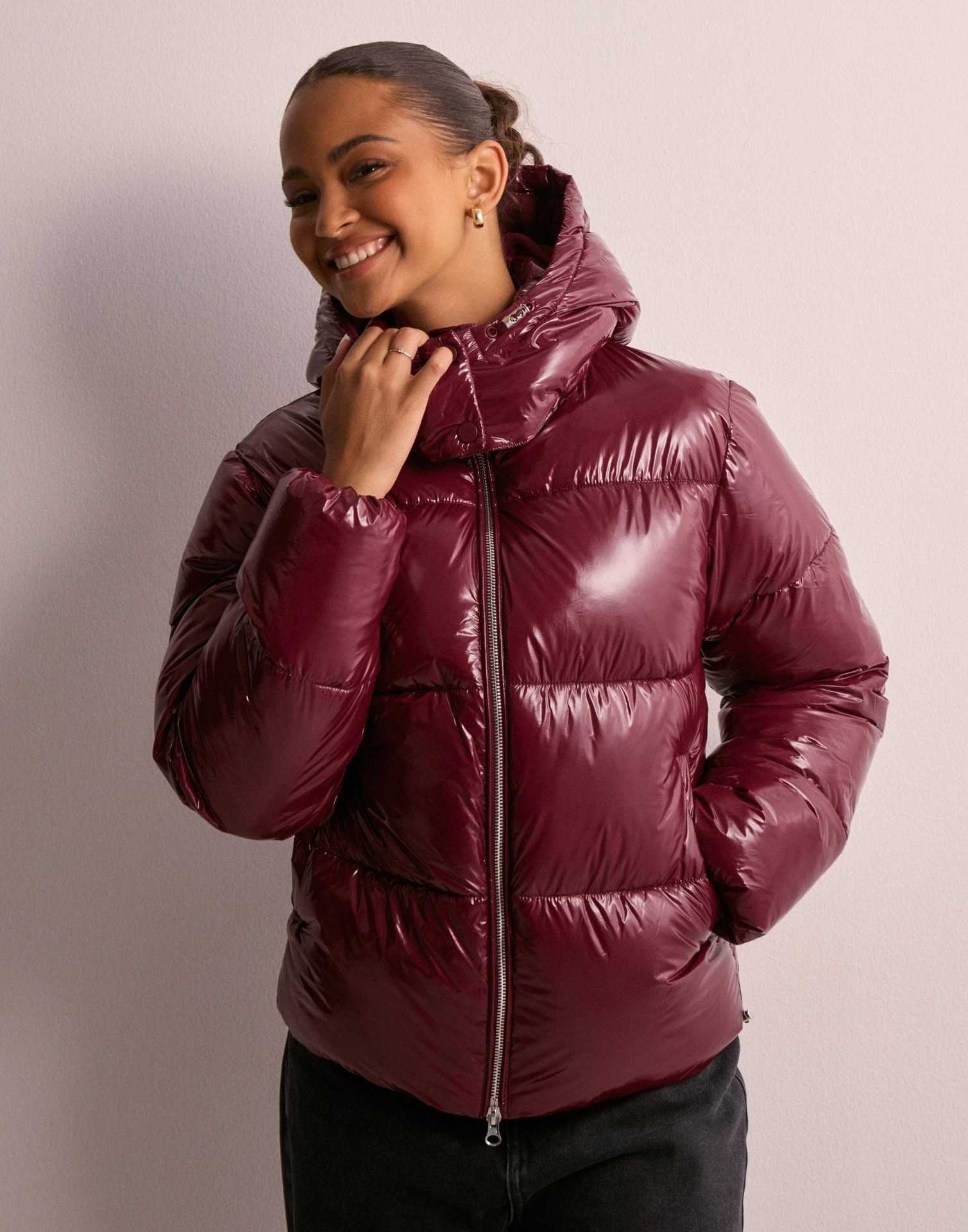 outfit mit bordeaux glänzender pufferjacke und schwarzer jeans