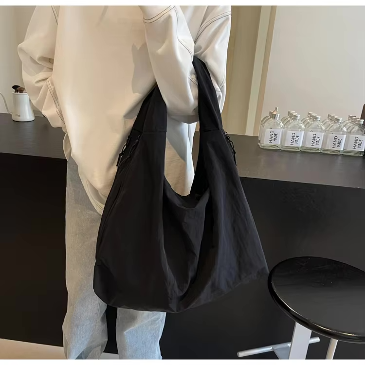 Frau trägt die schwarze Aether Tote Tasche