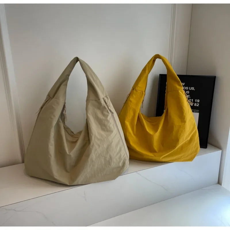 Beige und gelbe Aether Tote zusammen aufgestellt
