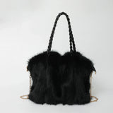 schwarze fluffy handtasche mit geflochtenem henkel und goldkette