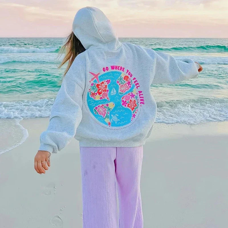 Grauer Hoodie Oversize Fit von Frau getragen am Strand
