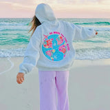 Grauer Hoodie Oversize Fit von Frau getragen am Strand
