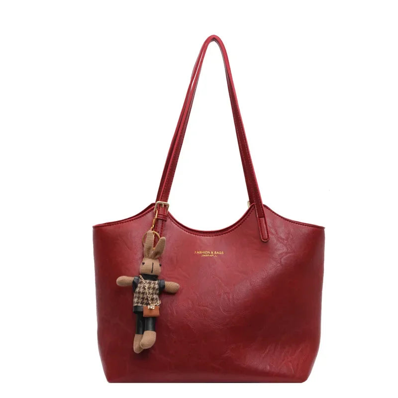 Rote Rustic Edge Bag auf Tisch mit Accessoires