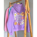 Bestickter Hoodie „Where the flowers meet the ocean“ in Lila auf Kleiderstange
