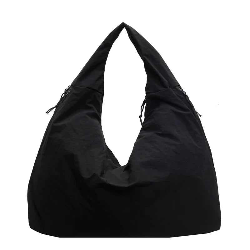 Schwarze Aether Tote Schultertasche auf Stuhl