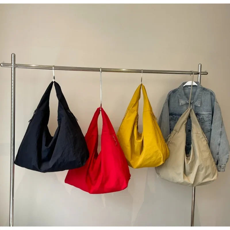 Aether Tote Schultertasche in Schwarz, Gelb und Rot nebeneinander