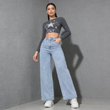 Modell trägt Lunira Wide-Leg-Jeans in Hellblau mit Crop-Top, Streetstyle-Frontansicht