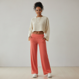 Modell in Aveline Wide-Leg-Hose Koralle und crèmefarbenem Oversized-Pullover, Casual-Streetstyle Frontansicht