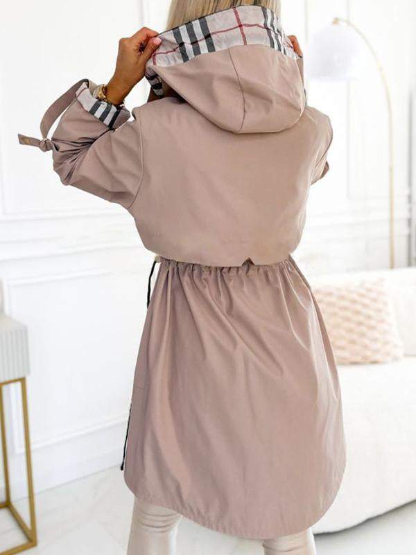 Khaki Trenchcoat mit Kapuze und Karodetail, offen getragen.