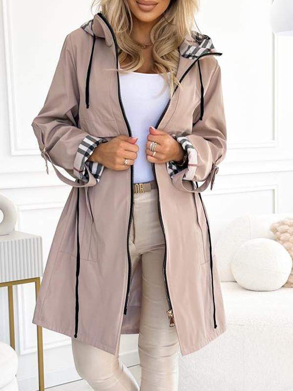 Khaki Trenchcoat mit Kapuze und Karodetail, offen getragen.