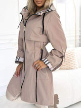 Khaki Trenchcoat mit Kapuze und Karodetail, offen getragen.