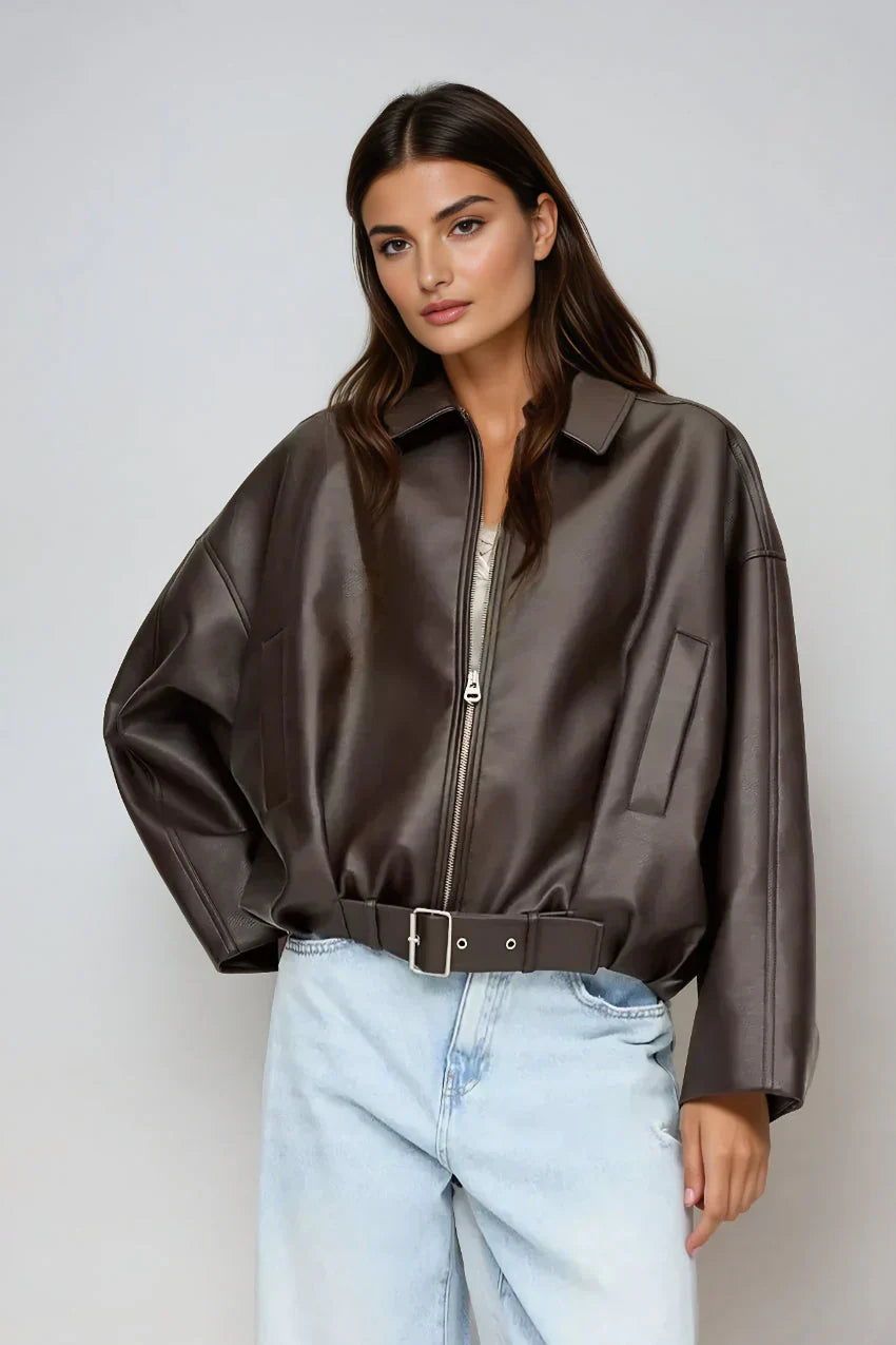 model trägt dunkelbraune oversized vegan-leder jacke mit reißverschluss und gürtel