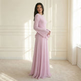 Modell trägt Elysera Maxikleid in Rosa/Lila mit Rüschen und Trompetenärmeln, Seitenansicht