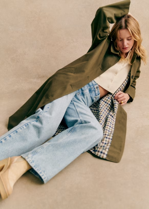 Clara Trenchcoat Oliv – liegendes Styling mit Gingham-Futter