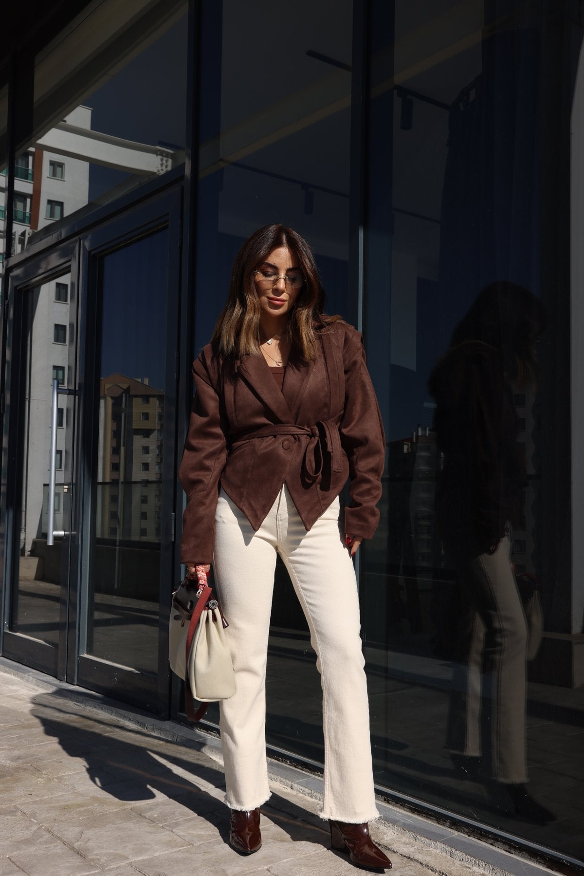 Streetstyle Look mit brauner vegane Wildlederjacke und weißer Hose